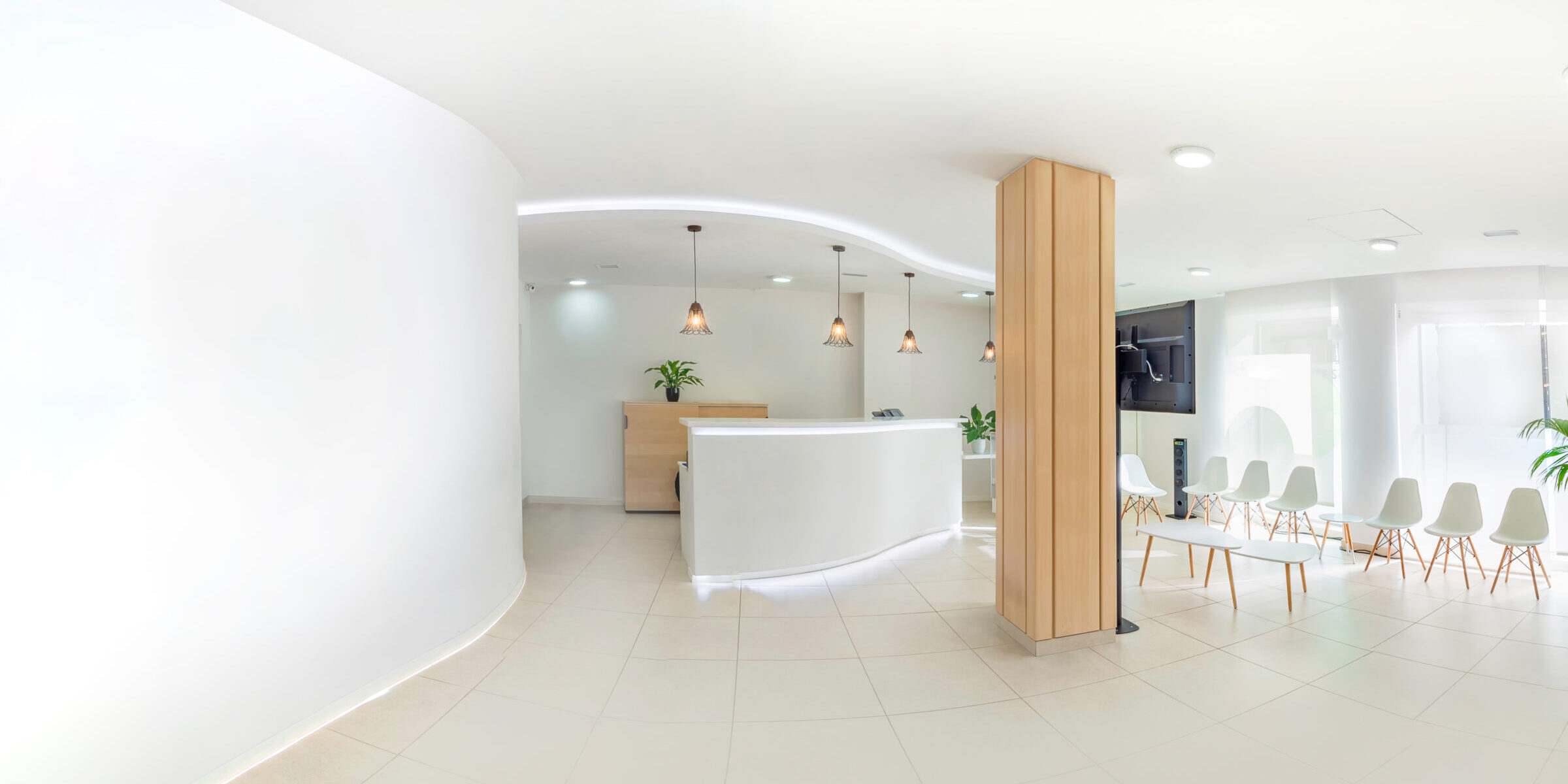 Panorama of a bright reception and waiting room in a clinic with desk, modern chairs and plants. Indoor mockup with screen with copy space.