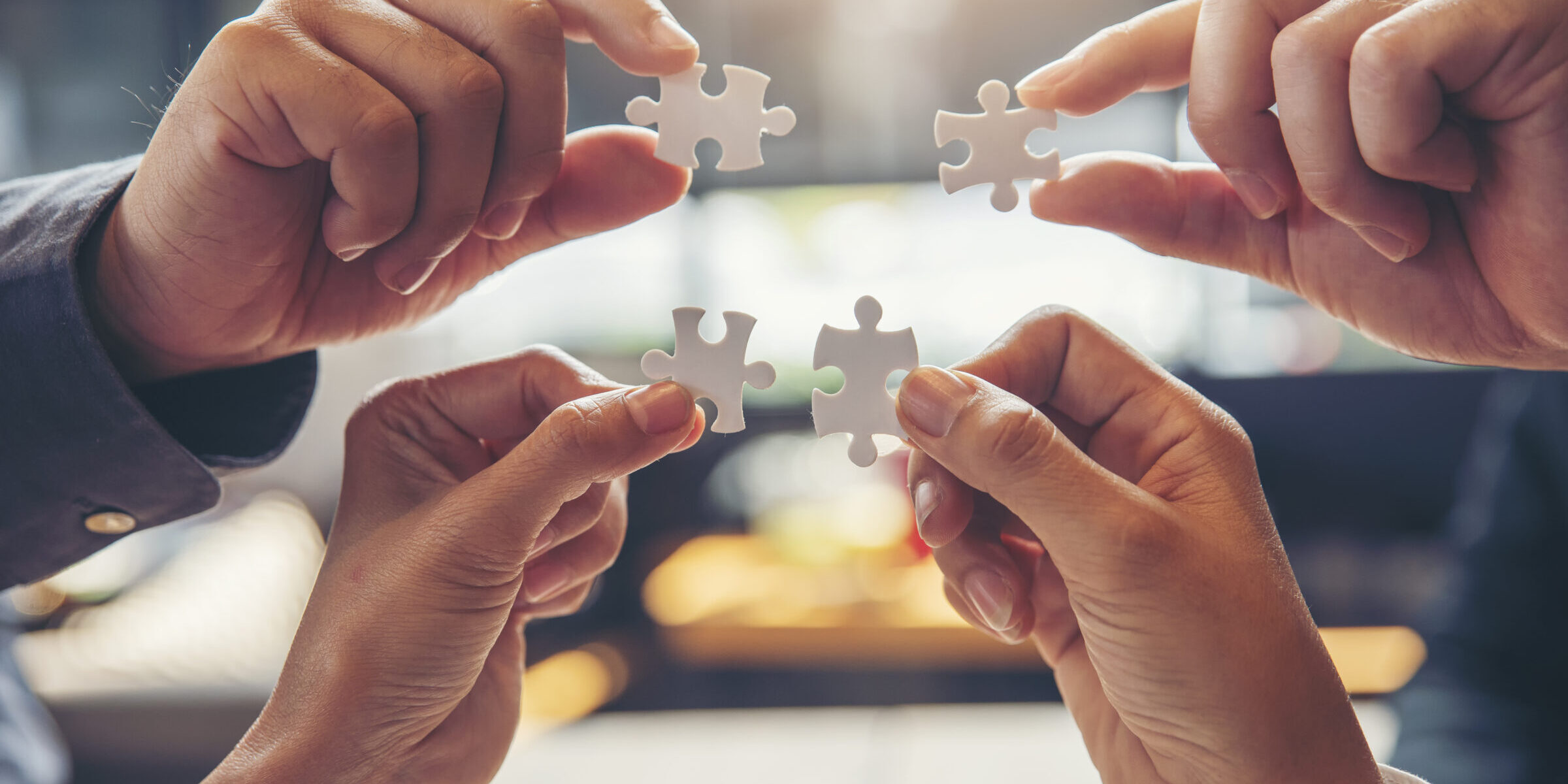 Strategy and Solution Business Concept.Group of Business people holding piece of jigsaw puzzle to solution problem on wooden desk.Professional Businessman and Partnership meeting in office.